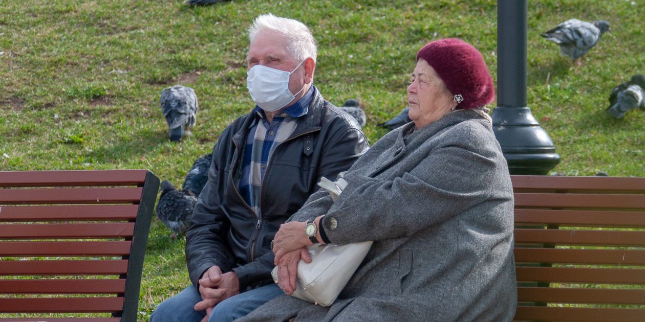 Пенсионеры в масках сидят на лавке