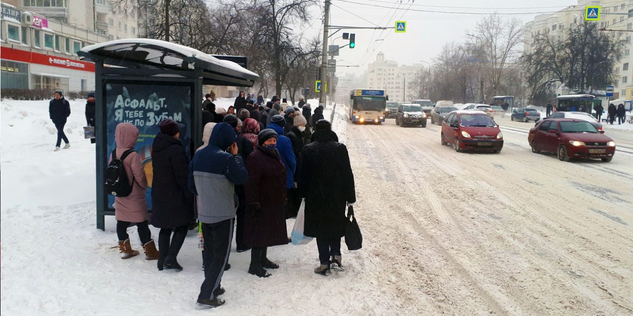 Пассажиры ждут автобуса на остановке в снегопад